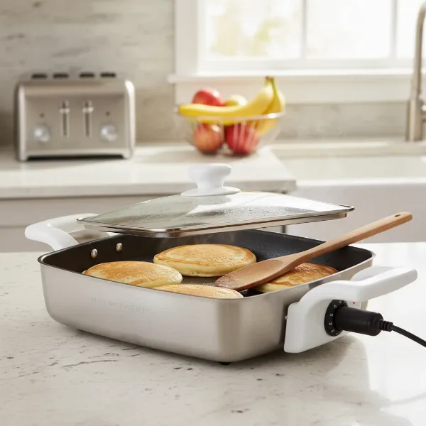 White Westinghouse electric skillet with food cooking, showing its practical features and design.